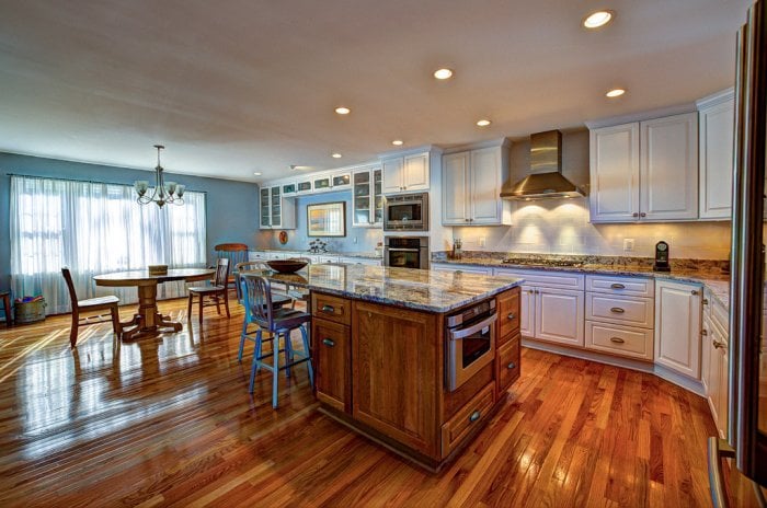 large kitchen with island, kitchen table with wood flooring